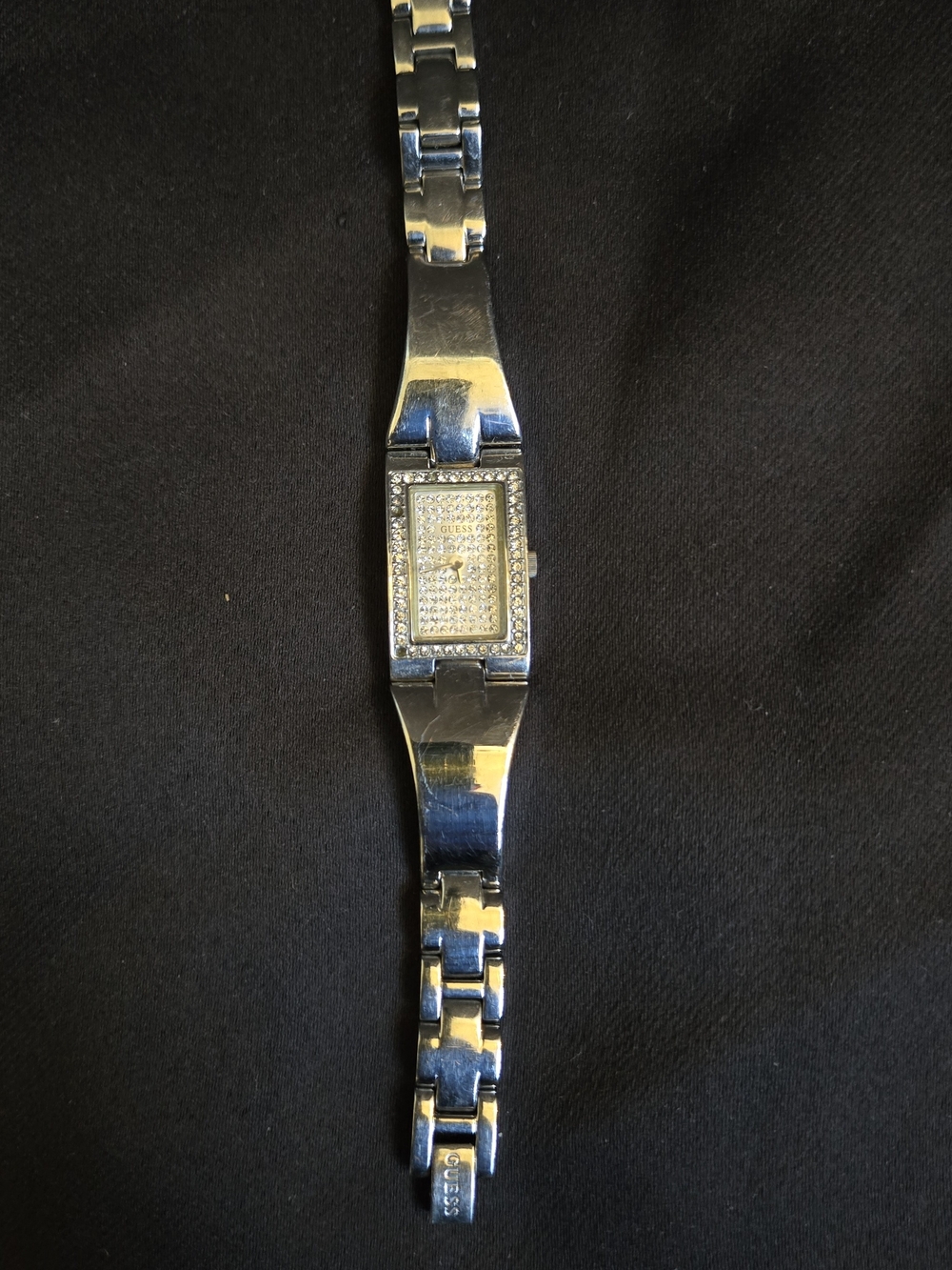 Silver-tone Guess rectangular quartz wristwatch featuring a pavé crystal-accente